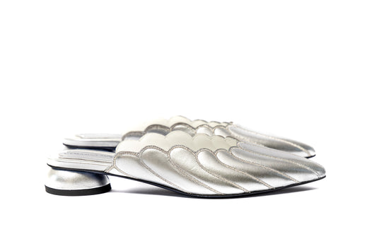  Mules Vanessa Cosmina Suçiu in pelle argento metallizzato con lavorazione a balze, profilo smerlato bianco e tacco basso 2 cm.
