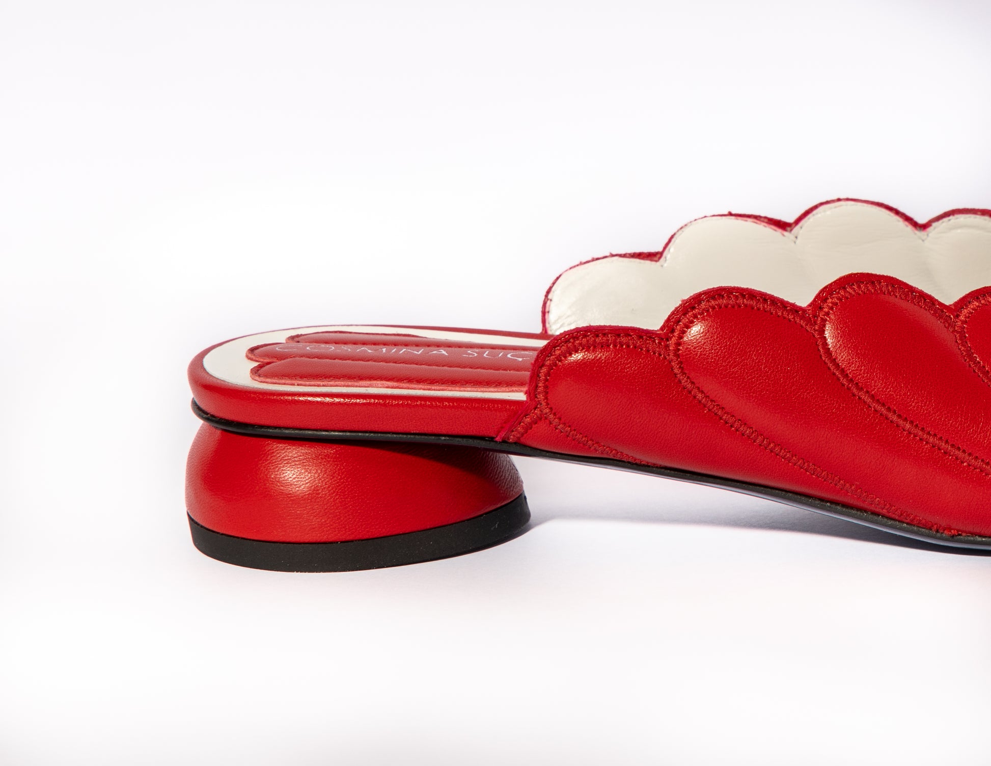 Mules Vanessa Cosmina Suçiu in pelle rosso intenso con lavorazione a balze, profilo smerlato bianco e tacco basso 2 cm.