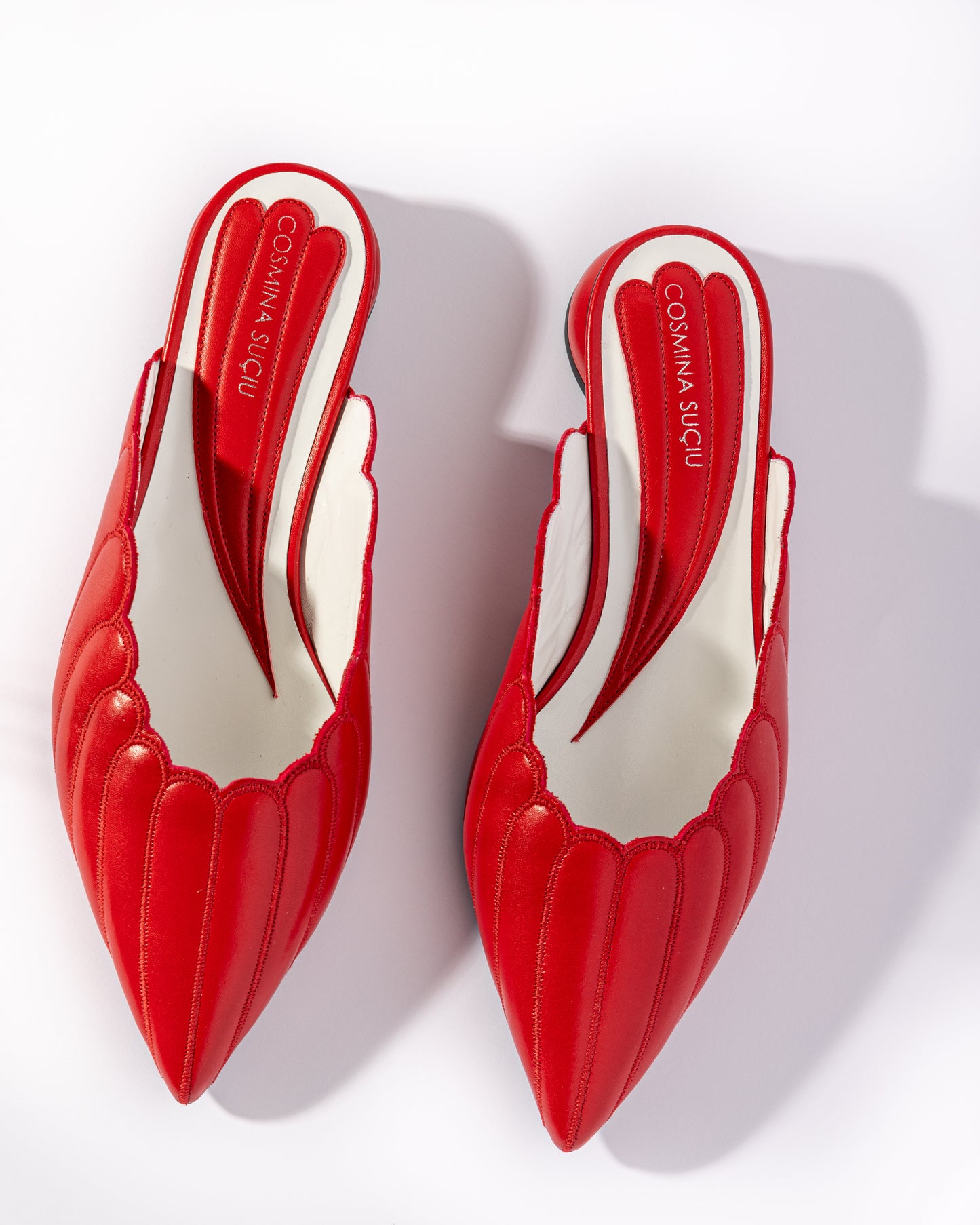 Mules Vanessa Cosmina Suçiu in pelle rosso intenso con lavorazione a balze, profilo smerlato bianco e tacco basso 2 cm.